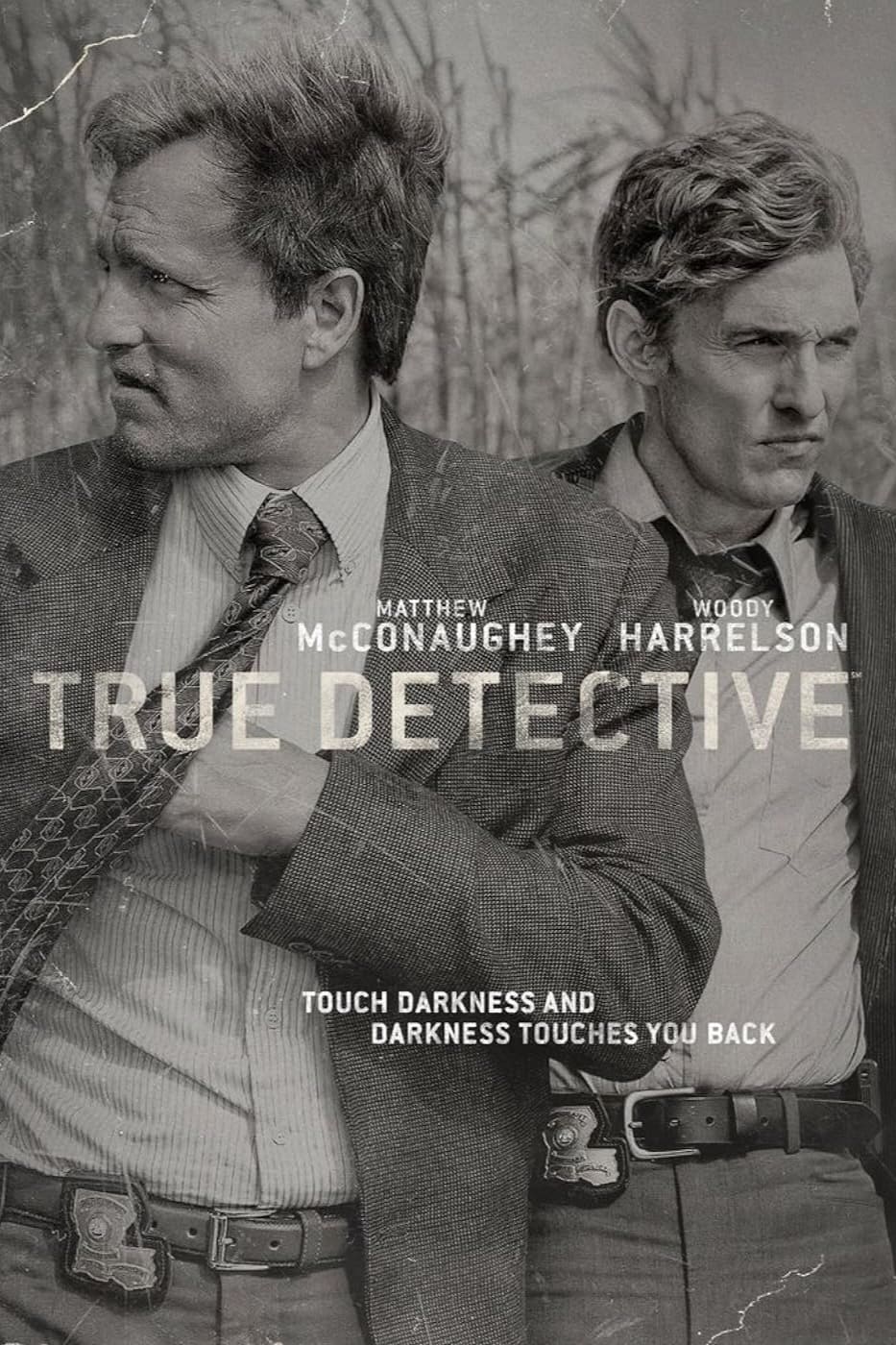 Two men in suits stand side by side, looking serious. Text reads Matthew McConaughey, Woody Harrelson, True Detective. Touch darkness and darkness touches you back. The image is black and white—a classic moment streaming on IPTV Latvia.