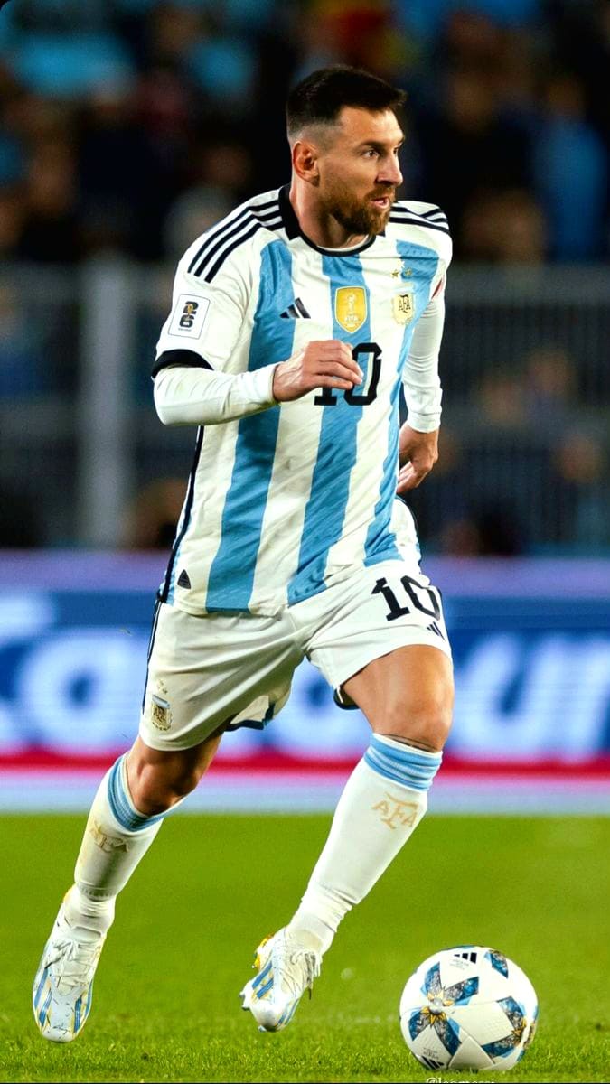 A soccer player in a blue and white Argentina jersey, number 10, runs on the field while dribbling a ball during a match, as fans from around the world—including those watching via IPTV Latvia—cheer on every move.